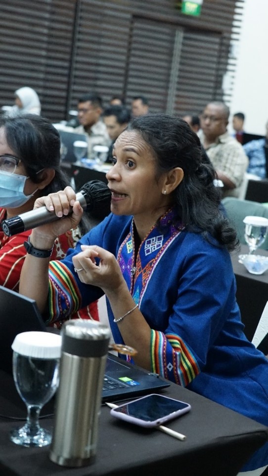 A woman, who participated in a training, held a microphone and speak in a session.