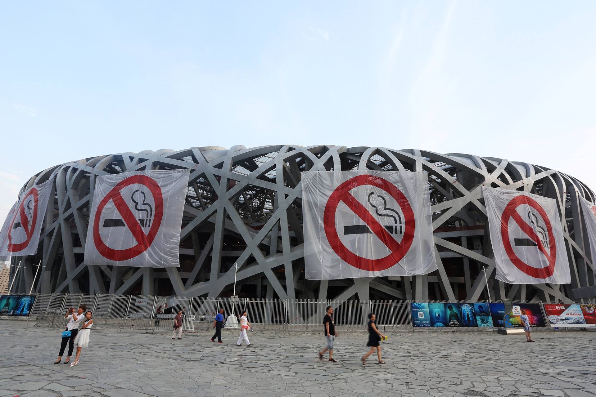 No smoking banners on a large building shaped like a bird's nest in China